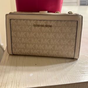 Cream colored Michael Kors wristlet. Super cute and convenient. Only worn once!